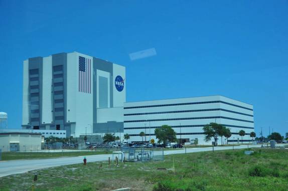 Gigantesco prédio de montagem de foguetes no Kennedy Space Center, no Cabo Canaveral, na Flórida - EUA. Apenas o quadrado azul da bandeira é do tamanho de uma quadra de basquete!